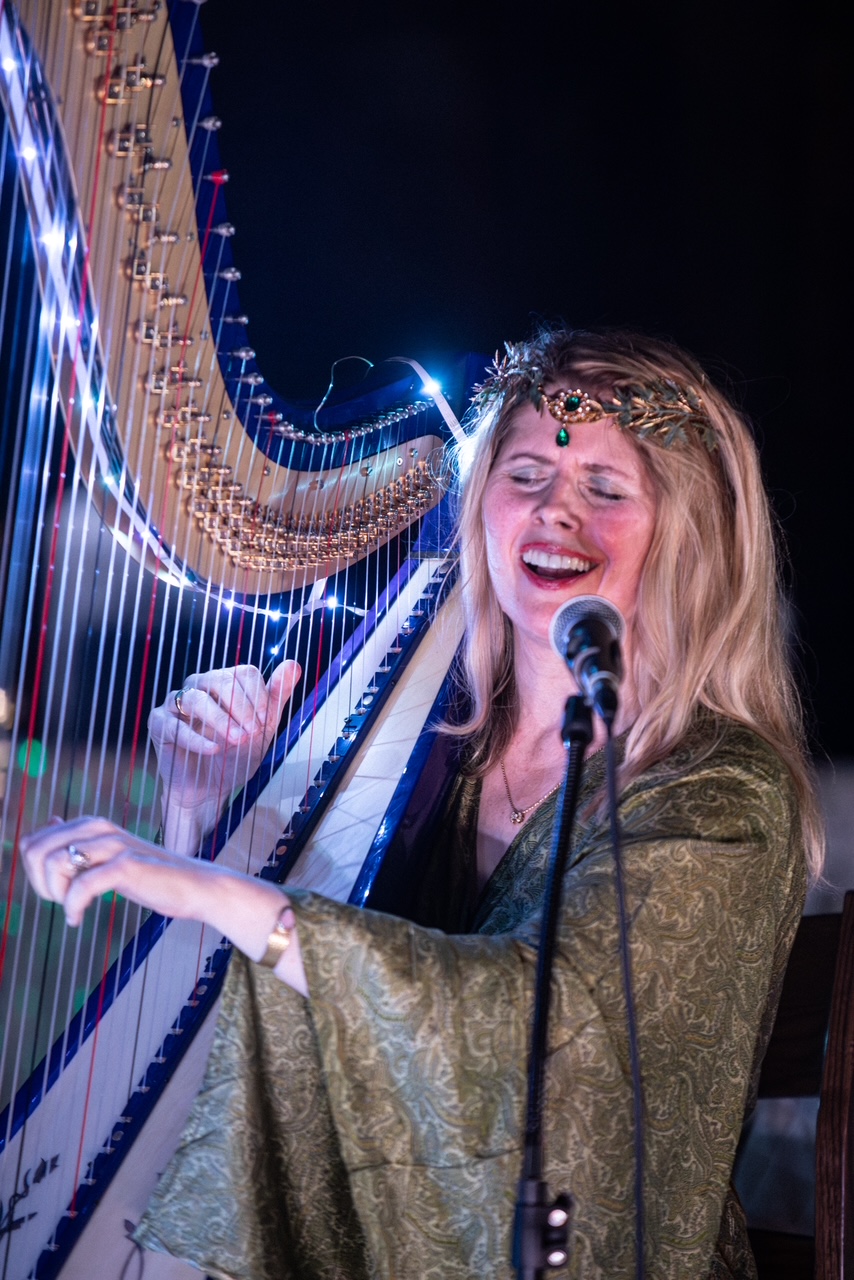 Helane Marie Anderson singing while playing the harp